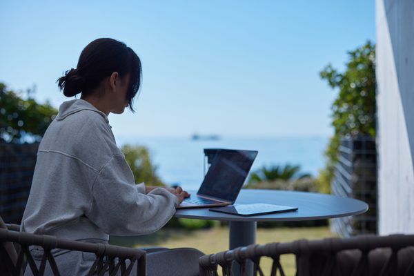海を前にテラスでノートパソコンを開く